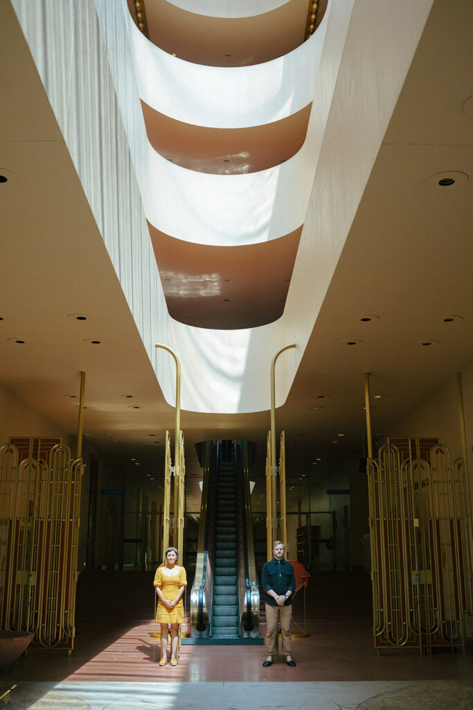 Creative Marin County Civic Center engagement photo with a couple standing beneath dramatic skylight.