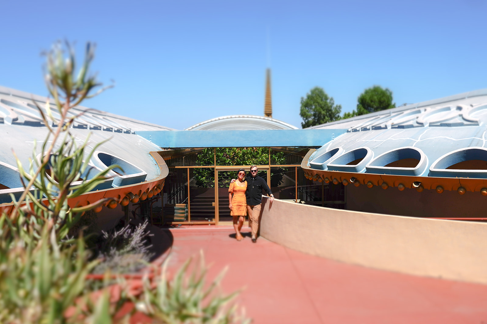 Creative engagement photo of a couple posing outside the curved architecture at Marin County Civic Center
