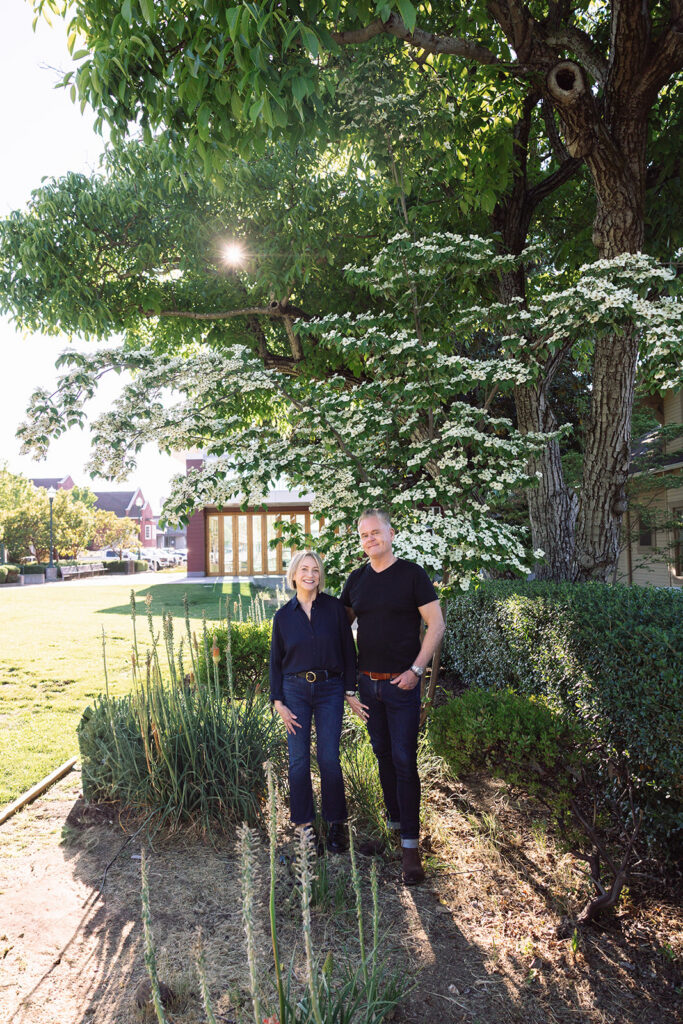 Couple posing for photos in a grassy garden area.