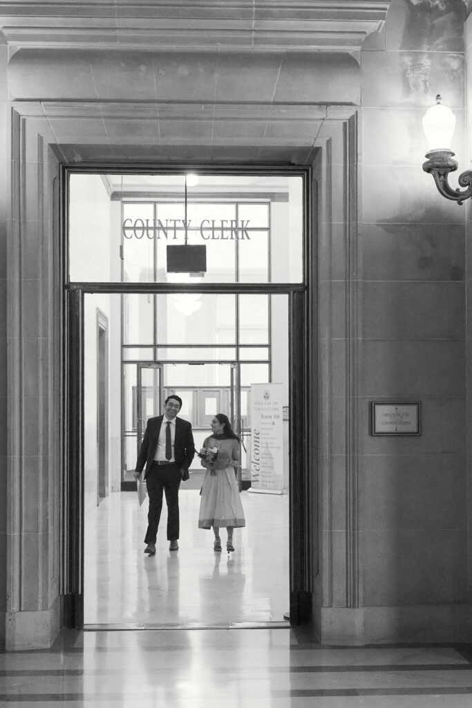 Couple walking from the County Clerk’s office before their San Francisco City Hall wedding ceremony.