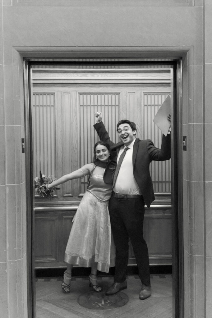 Bride and groom celebrating together inside an elevator at San Francisco City Hall.