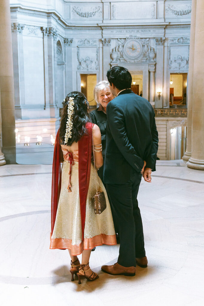 Bride and groom speaking with their officiant before their City Hall wedding ceremony.