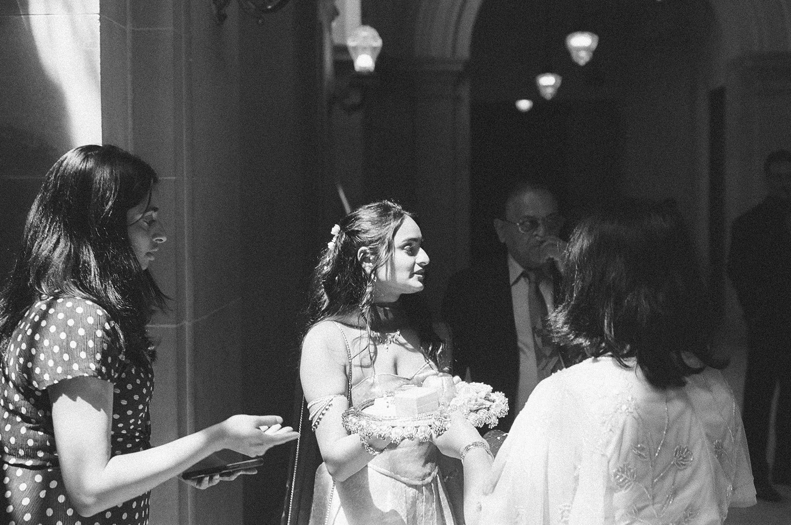 Candid black and white photo of a bride mingling with family after her civil wedding.