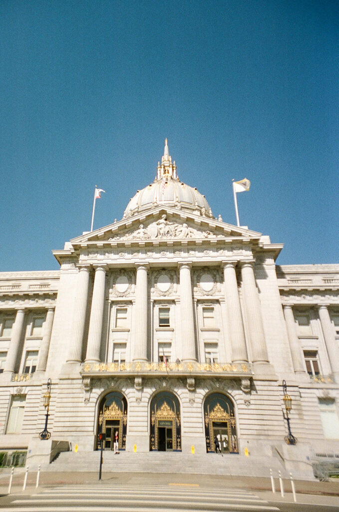 Exterior of San Francisco City Hall photographed on film beneath a bright blue sky.