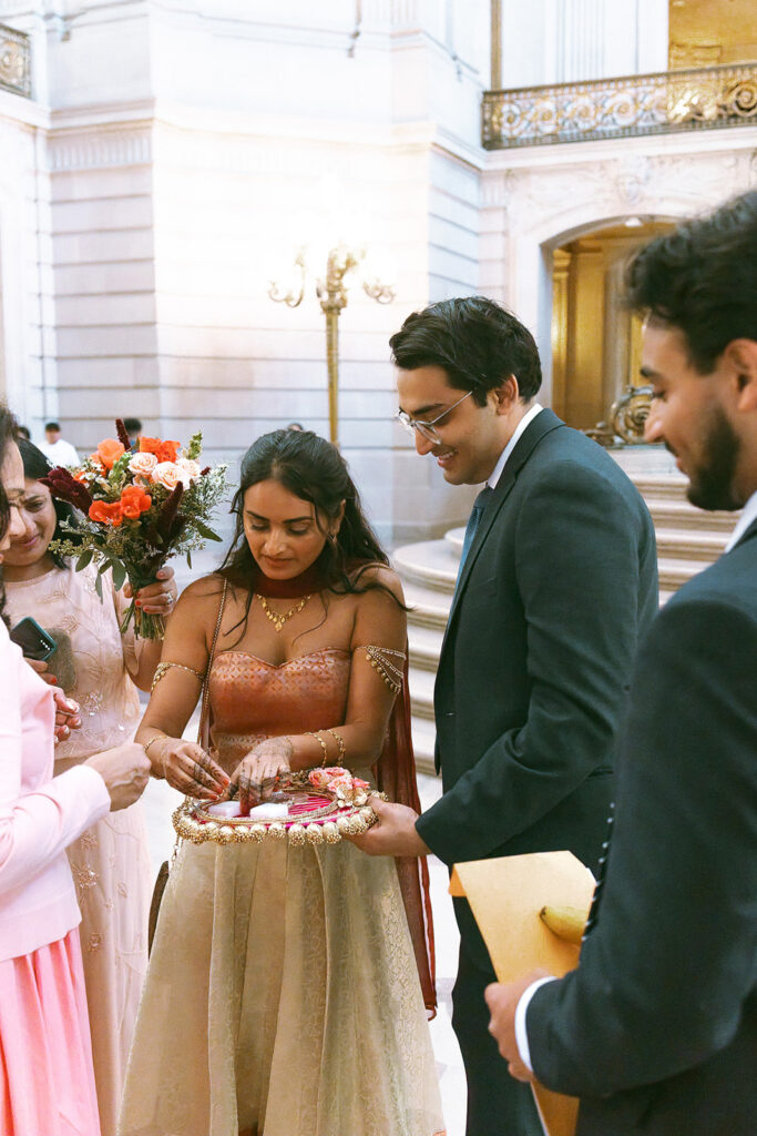 Bride with family and friends holding a decorative wedding tray.