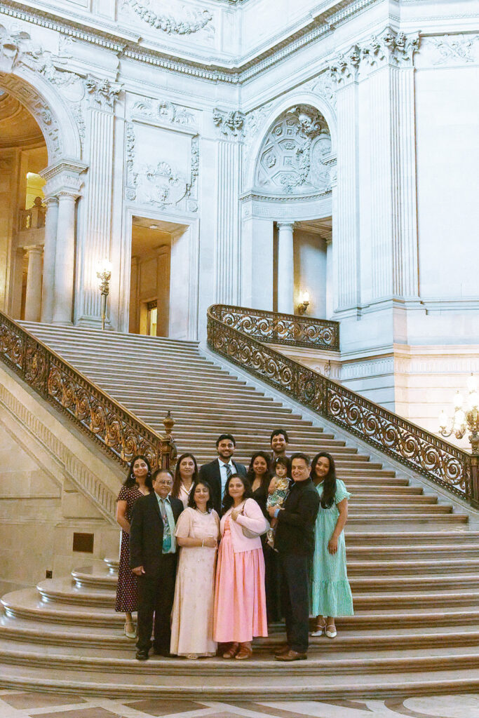 Family gathered for a group portrait on the grand staircase at San Francisco City Hall.