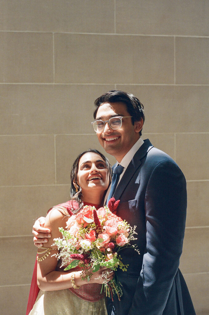 Bride and groom smiling together during their San Francisco City Hall wedding portraits.