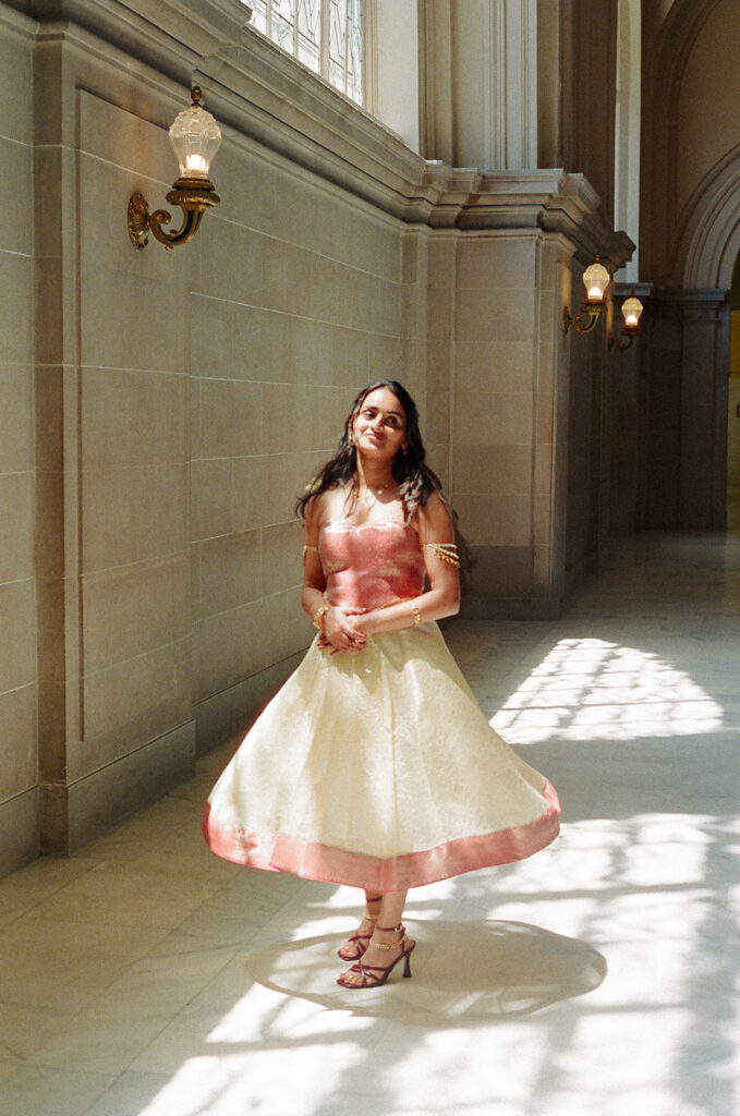 Bride standing in a sunlit marble hallway during her San Francisco City Hall wedding.