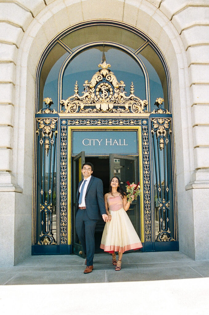 Couple walking out of the San Francisco City Hall after their wedding captured on film.