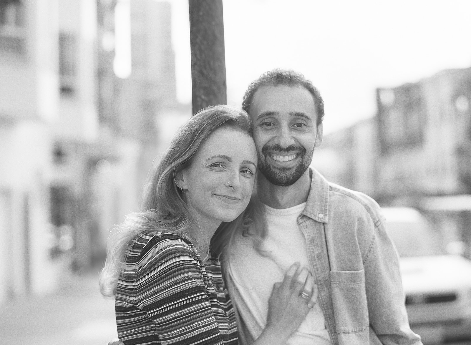 Black and white photo of a couple smiling together for their SF engagement photos in North beach.
