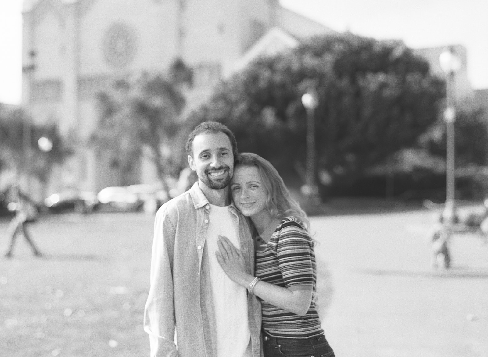 Black and white photo of a couple posing together at Washington Square Park outside of Saints Peter and Paul Church.