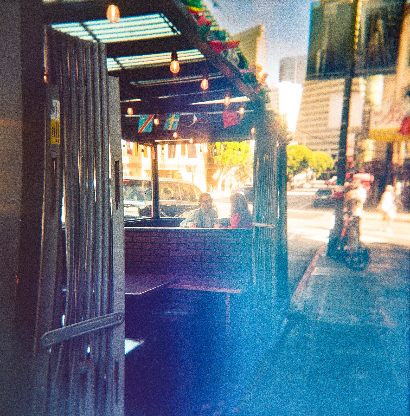 35mm film photo of a couple sitting together at Caffe Trieste in North Beach for their SF engagement photos.
