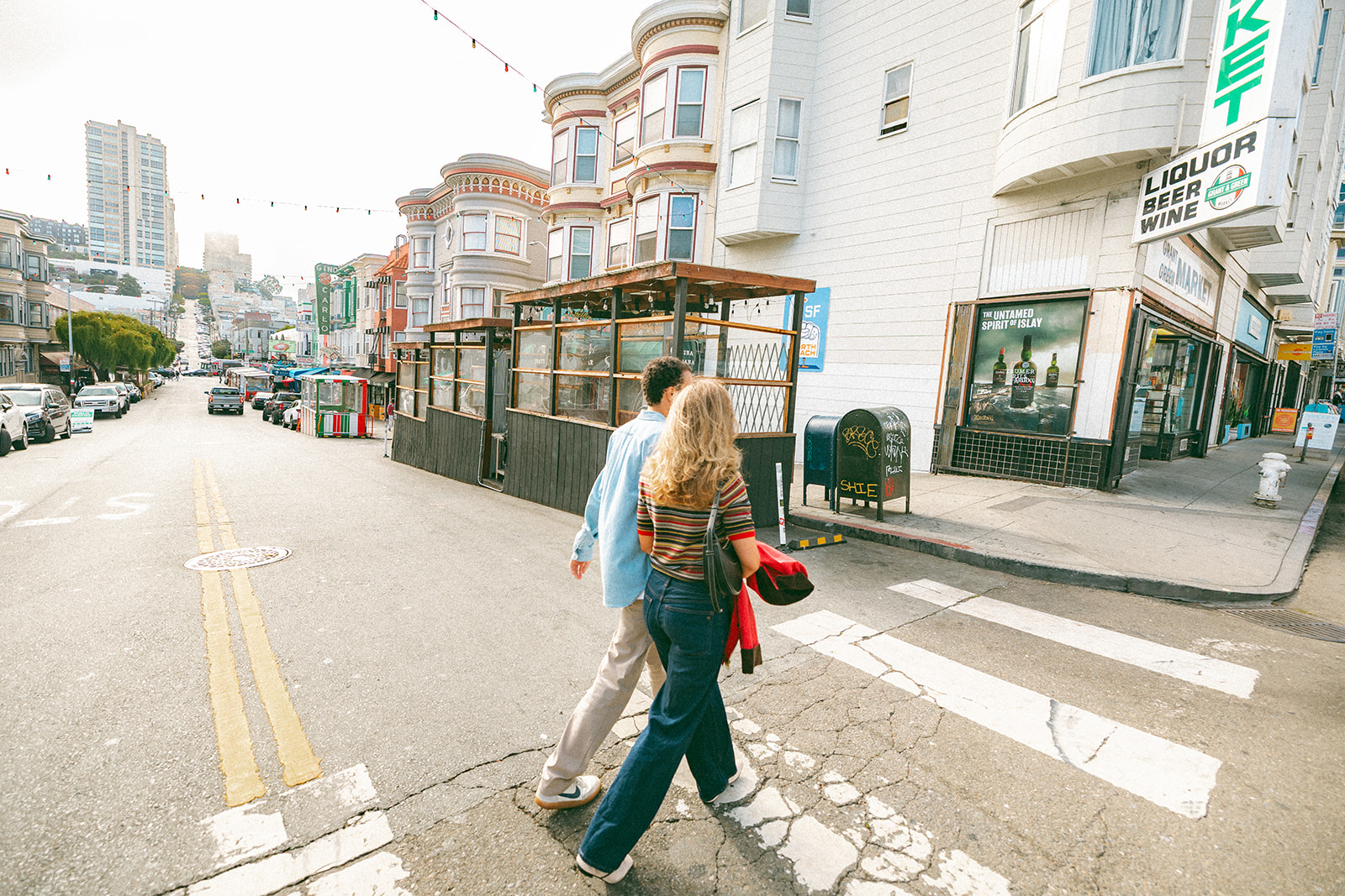 Candid photo of a couple crossing the street in North Beach for their SF engagement photos. 