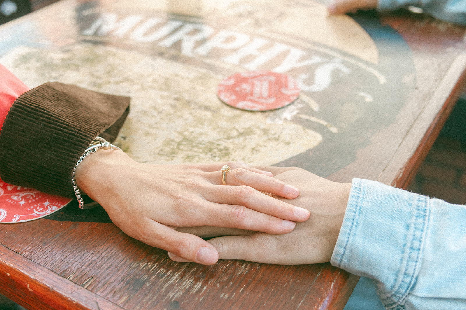 Close up photo of a couple holding hands at a table outside of Caffe Trieste.