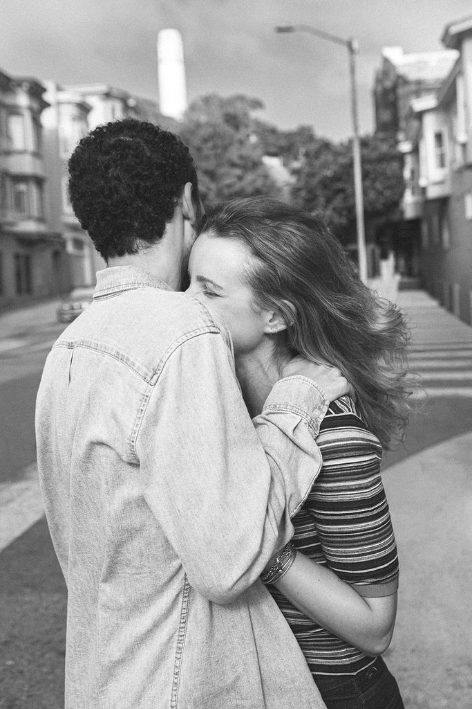 Black and white photo of a couple embracing in North Beach.