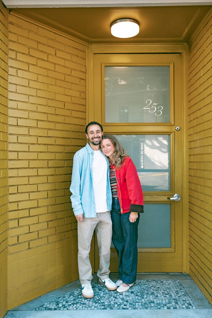 Couple posing next to a door in North Beach in SF.