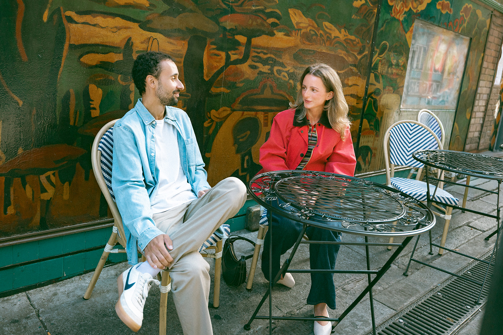 Couple sitting at an outside table at a cafe.