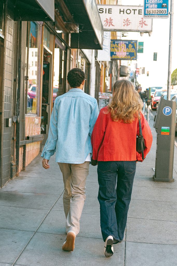 Couple walking down the street for their SF engagement photos in North Beach.
